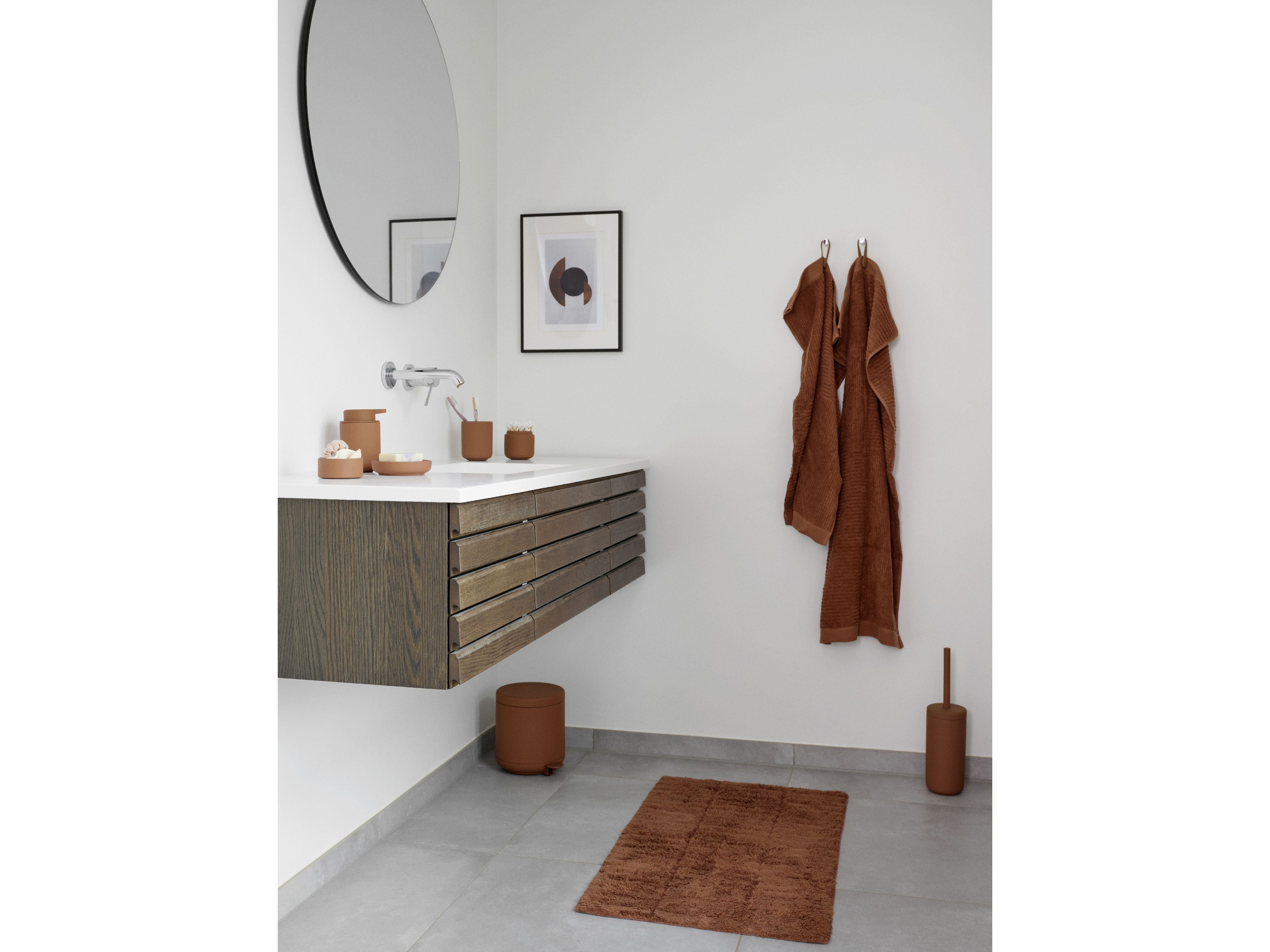 A bathroom with brown towels and a Zone Denmark Ume Pedal Bin 4 Liter, Terracotta.