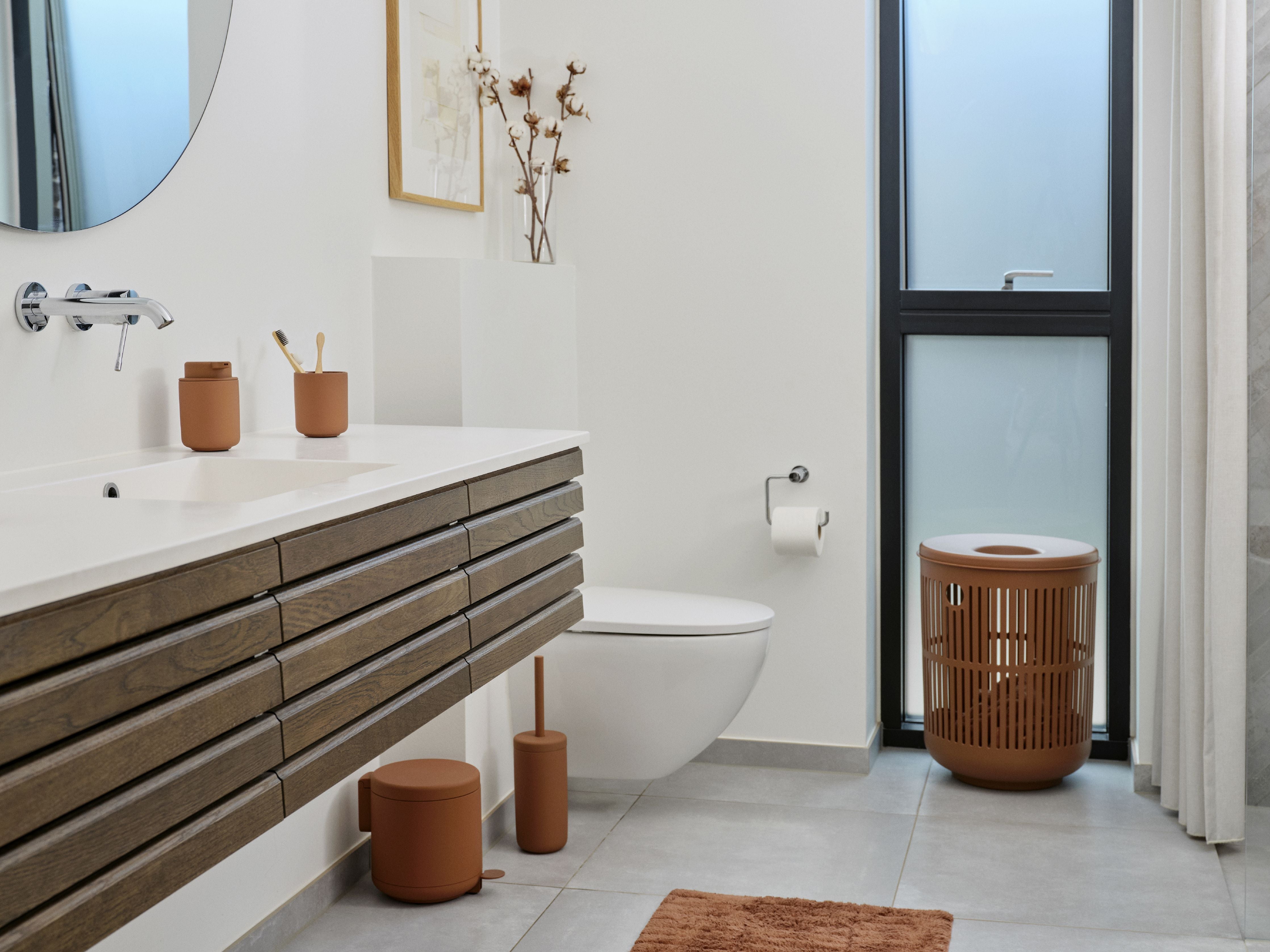 A bathroom with a toilet, sink, and a Zone Denmark Ume Pedal Bin 4 Liter in Terracotta.